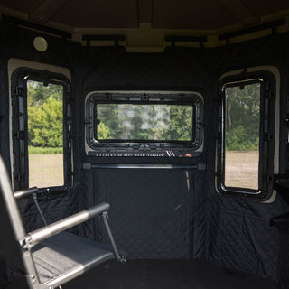 The image is showing the view from inside an Alpha Hunting Blind, focusing on three windows. The window in the center of the image is landscape oriented while the two windows on either side are portrait oriented. With double gasket-sealed glass and silent friction hinges, the Alpha Hunting Blind has the most superior windows on the market. They are durable, do not become cloudy, silent when opening and can be opened with one hand, and seal tight to keep the weather and unwanted pests out completely.